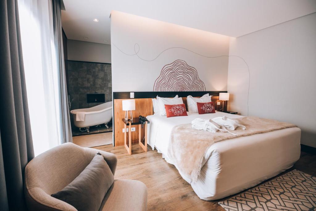 Quarto da Villa Amista com banheira e decoração moderna em tons claros