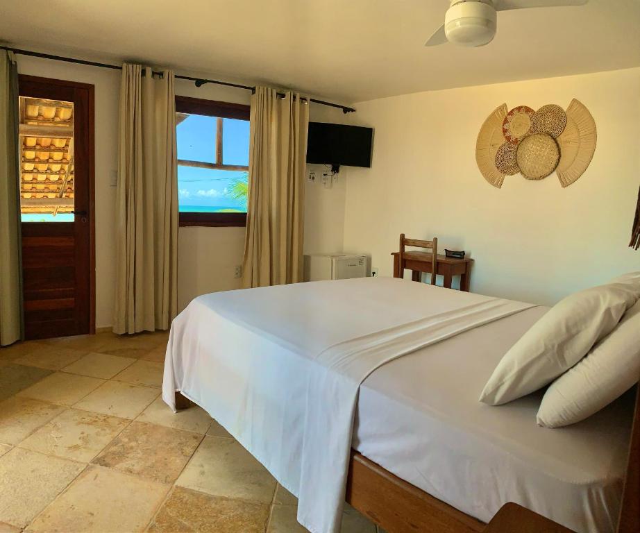 Quarto da Pousada Borboleta em Canoa Quebrada com cama de casal e janela com vista para o mar