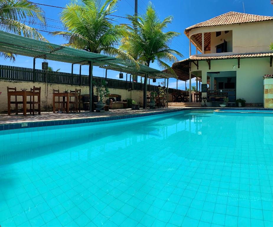 Piscina da Pousada Borboleta em Canoa Quebrada com área de descanso e coqueiros