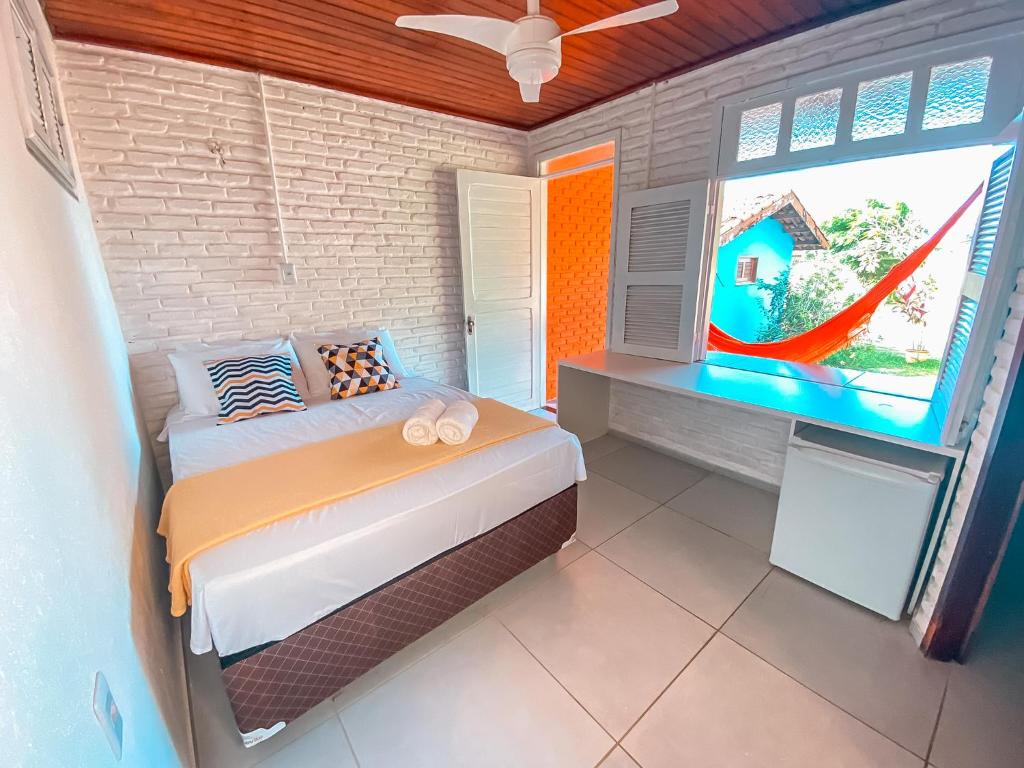 Quarto do Hotel Sunshine Centro Cumbuco com janela aberta e rede vermelha