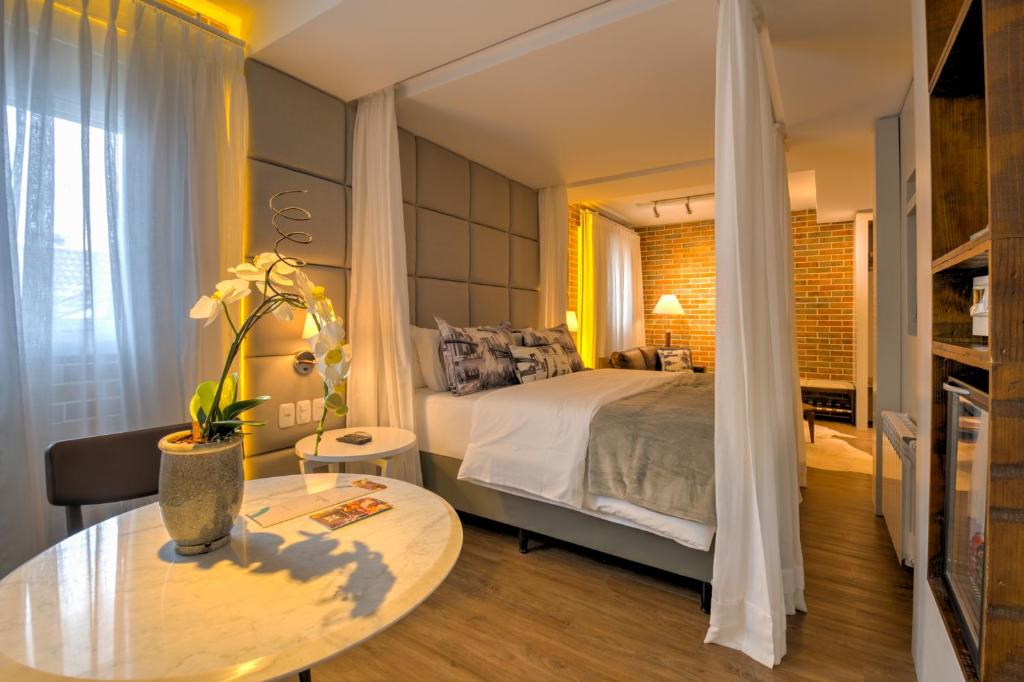 Suíte do Hotel Cercano com cama de casal, iluminação aconchegante e decoração moderna