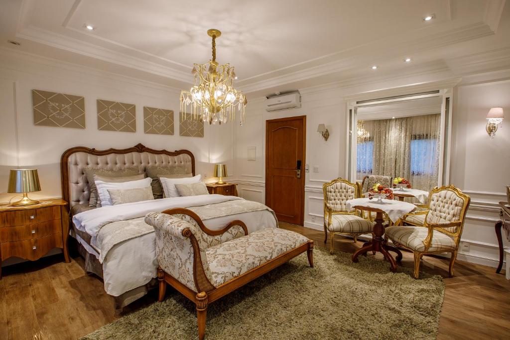 Suíte do Hotel Ritta Höppner com móveis clássicos e lustre elegante