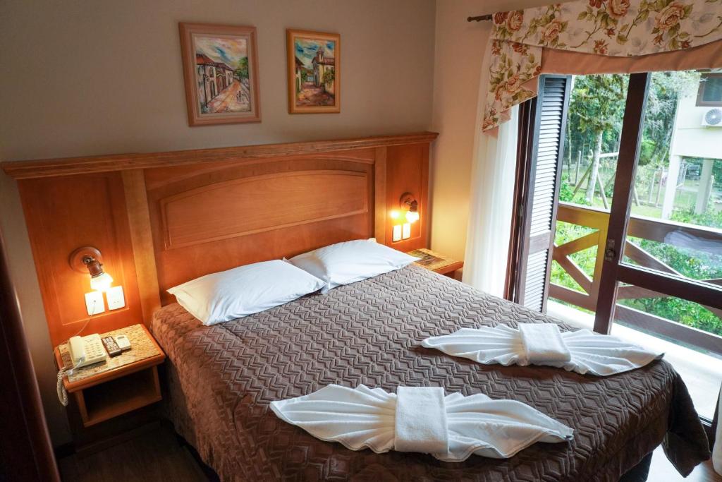 Quarto da Pousada das Papoulas com varanda e decoração simples em madeira