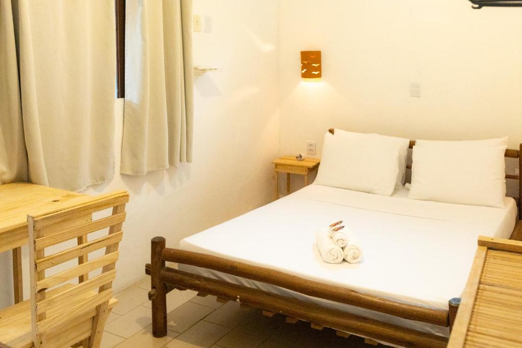 Quarto da Maré Mansa Pousada e Hostel em Itacaré com cama de casal e móveis de madeira clara