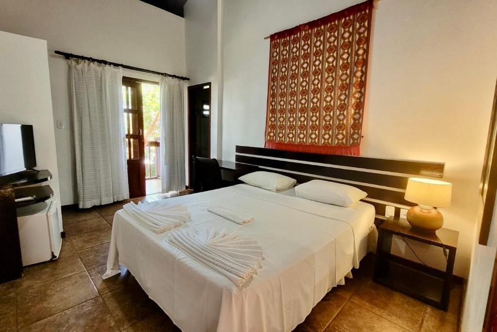 Quarto da Pousada Coqueiro Verde em Itacaré com cama de casal e decoração simples