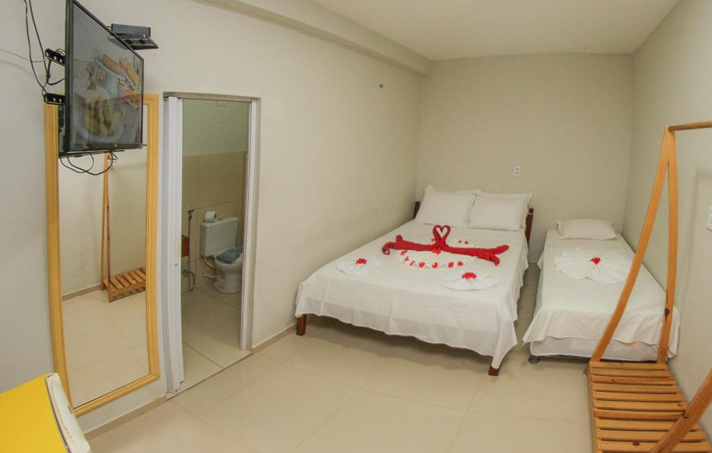 Quarto da Pousada Jerimar com cama de casal, cama de solteiro e decoração romântica