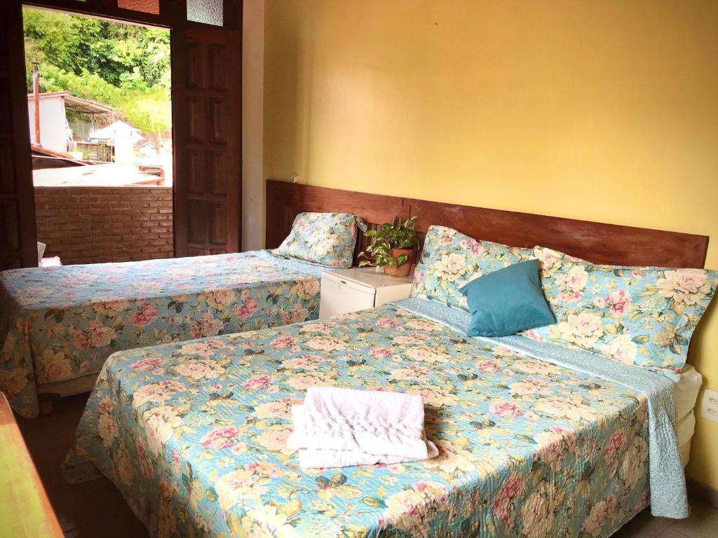 Quarto da Pousada Morro Bello em Morro de São Paulo com duas camas e decoração floral