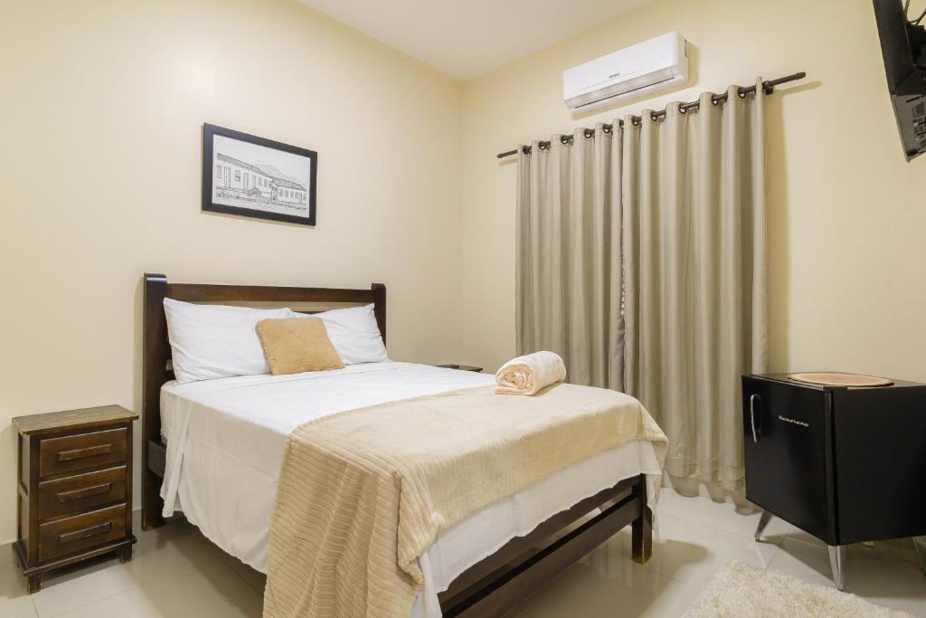 Quarto da Pousada Meia Ponte em Pirenópolis com decoração simples em tons claros