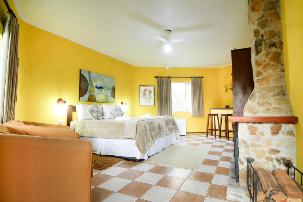Suíte espaçosa na Pousada Highland em Santo Antônio do Pinhal, com lareira e decoração moderna