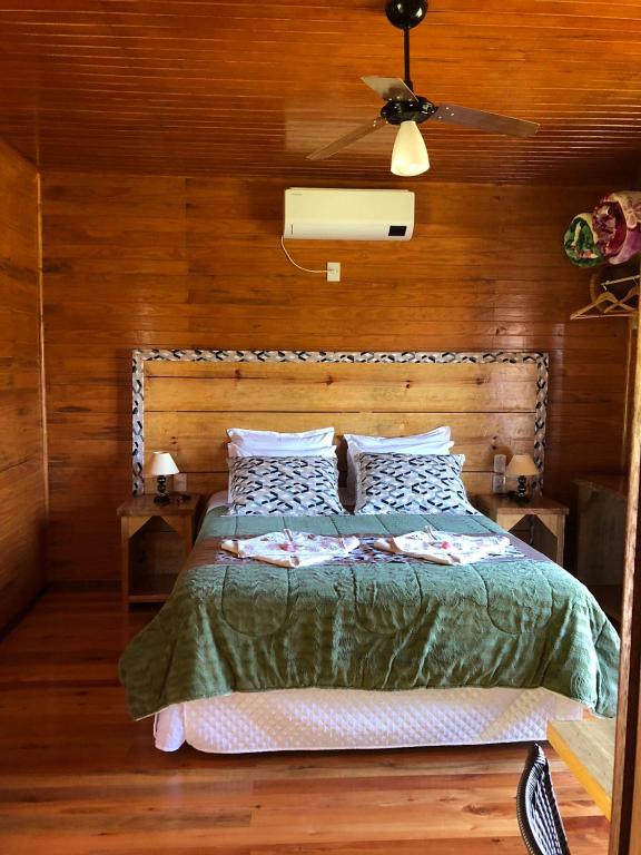 Quarto da Hospedagem Família Cruz em Urubici com paredes de madeira e cama de casal