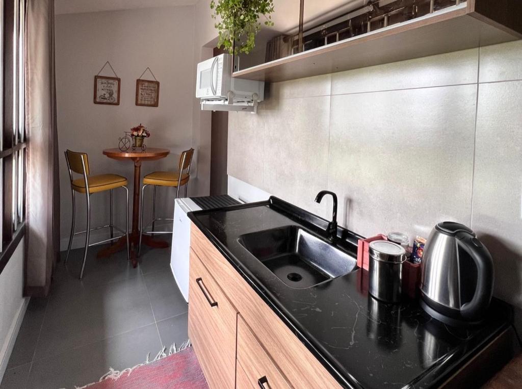 Cozinha compacta dos Lofts Urbano em Urubici com pia preta, mesa pequena e decoração moderna