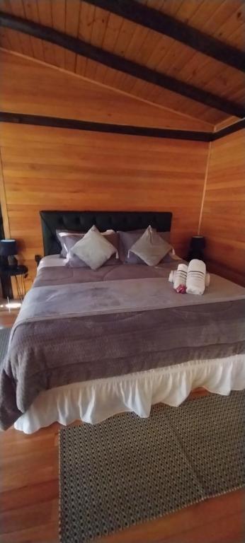 Quarto de madeira da Sentiero Cabanas Boutique em Urubici com cama de casal e teto inclinado
