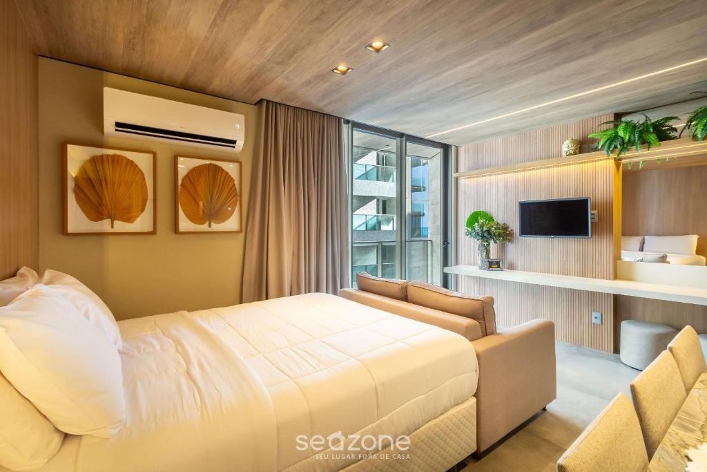 Quarto do NWTS Estúdios com vista lateral do mar em Maceió com cama de casal e varanda com vidro