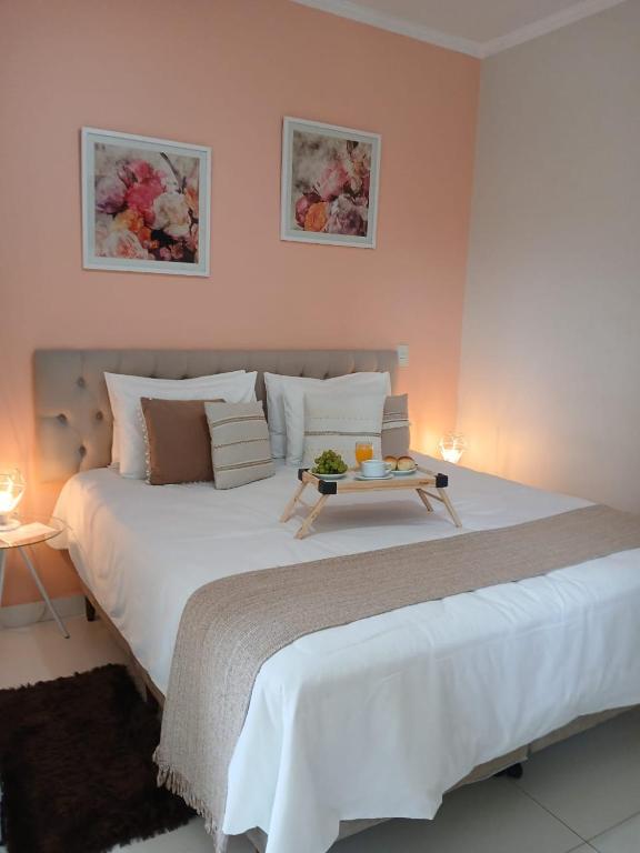 Quarto da Hospedagem Quarto Chic Centro Cunha com cama de casal e decoração em tons rosados