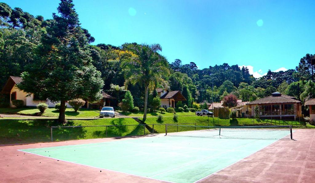 Quadra de tênis da Pousada Rosa, em Gramado, cercada por jardins, chalés e mata
