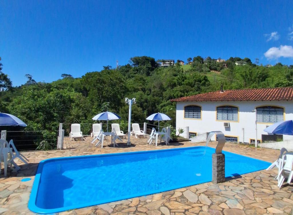 Piscina da Pousada 3 Corações Penedo com vista para as montanhas.