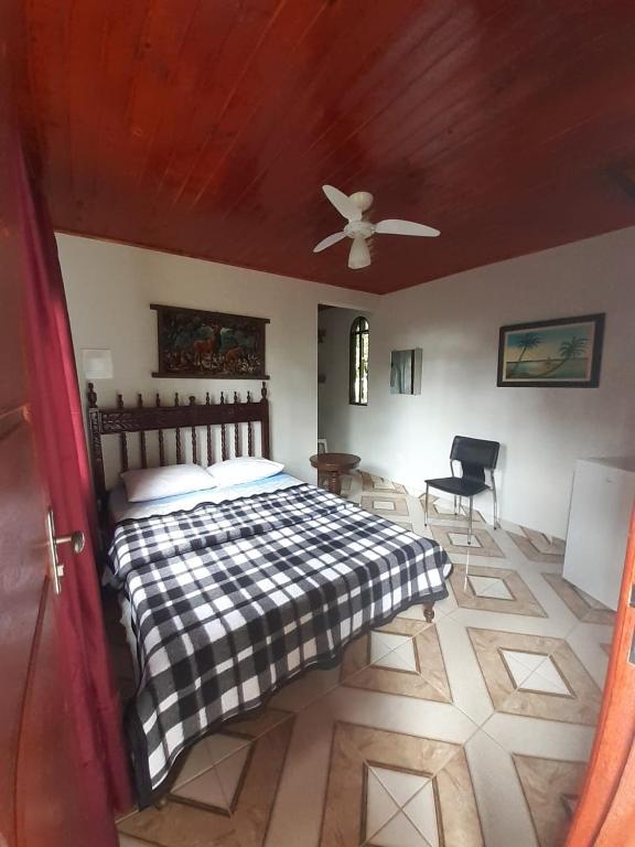 Quarto da Toca da Onça em Penedo com cama de casal e decoração rústica.