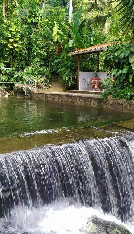 Piscina natural da Toca da Onça em Penedo cercada por mata preservada.