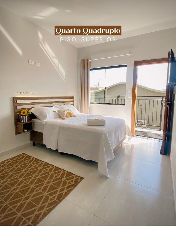 Quarto quádruplo da Pousada Villa Vantino em Penha com varanda e iluminação natural.