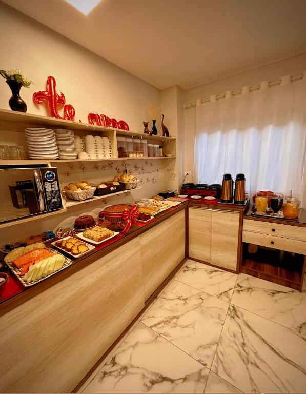 Café da manhã da Pousada Villa Vantino em Penha, com bolos, pães e bebidas servidos em buffet.