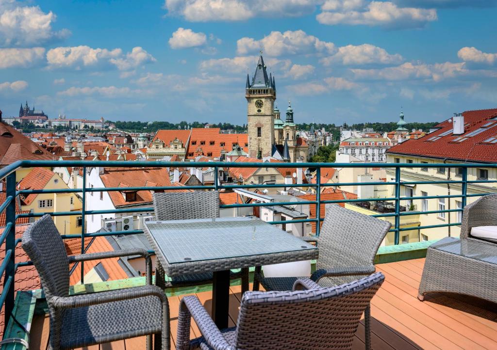Terraço do Hotel Leon D’Oro, em Praga, com mesa, cadeiras e vista para os telhados do centro histórico