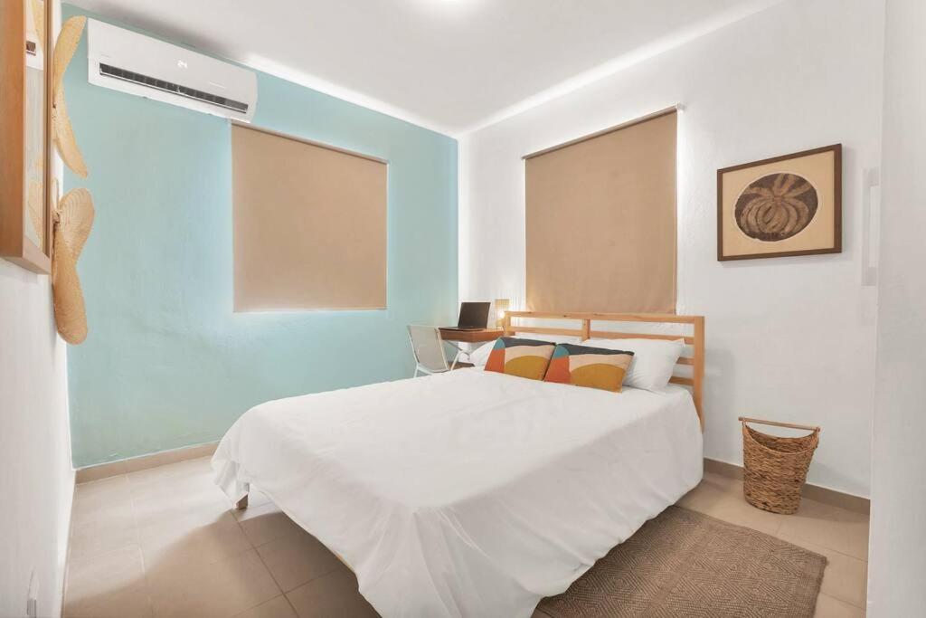 Quarto do Oasis Punta Cana Apartment, com cama de casal branca, parede azul-clara e persianas bege