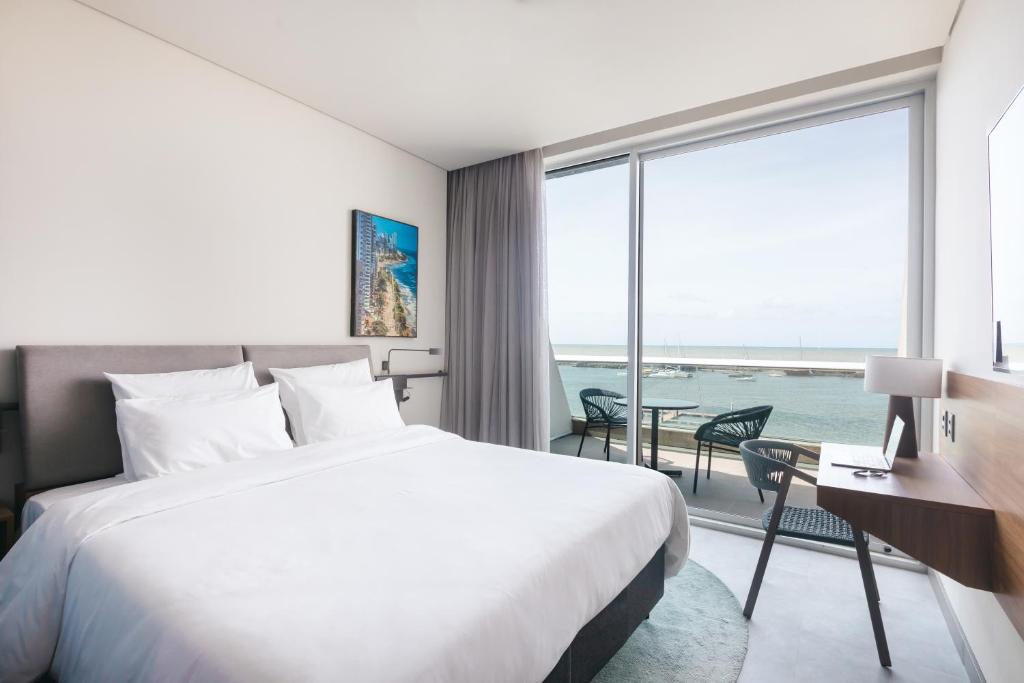 Quarto com varanda e vista para o mar no Novotel Recife Marina em Recife.