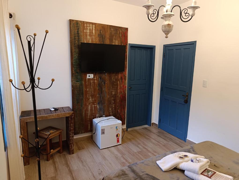 Quarto da Casa da Tuta Pousada em Tiradentes com portas azuis e móveis rústicos.
