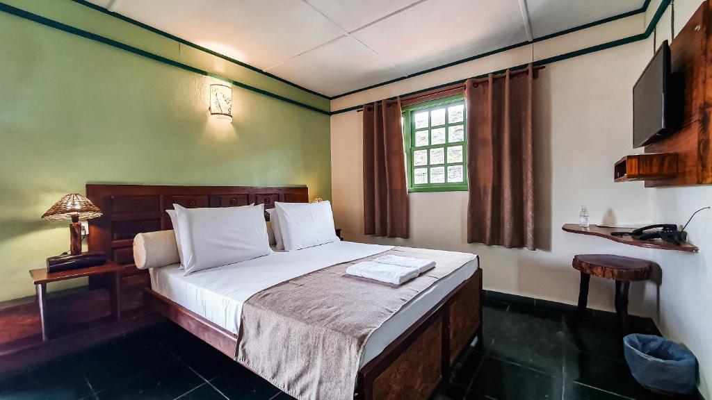 Quarto da Pousada Monte Azul na Chapada Diamantina com móveis de madeira escura.