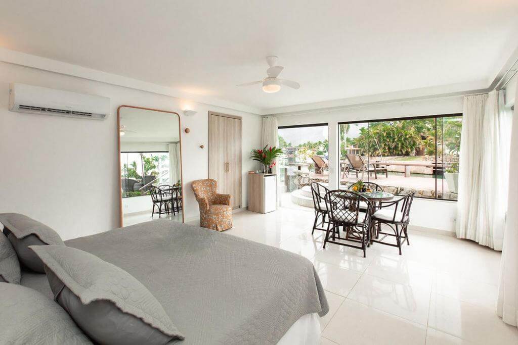 Quarto do Angra Boutique Hotel, com cama de casal, mesa junto à janela e vista para a piscina