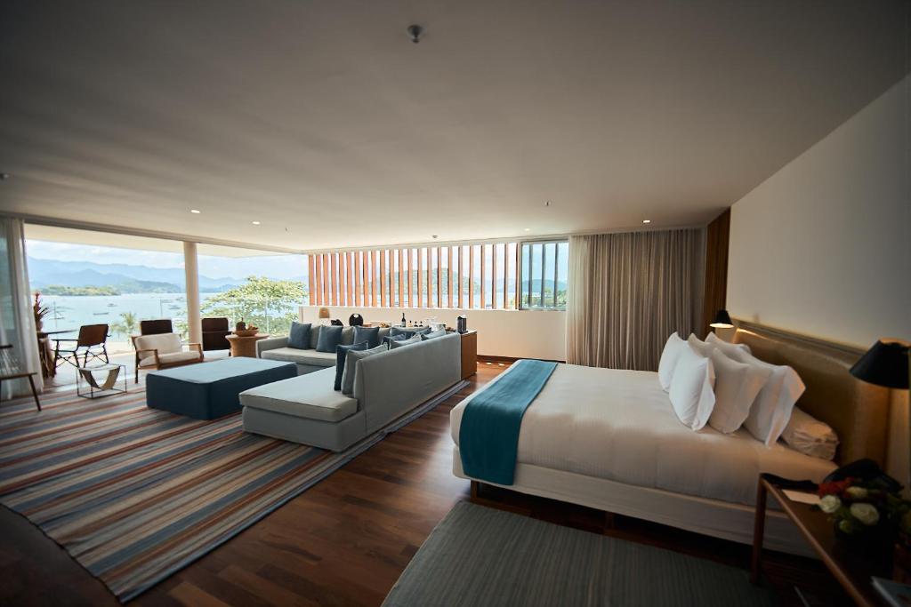 Suíte do Hotel Fasano Angra dos Reis, com cama, sala integrada, varanda e vista para o mar