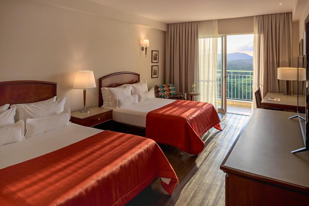 Quarto do Bourbon Resort Atibaia, com duas camas e varanda voltada para as montanhas