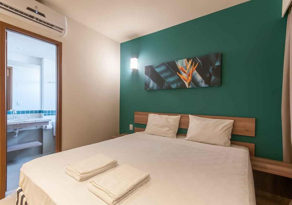 Quarto do Enjoy Solar das Águas Park Resort, com cama de casal e parede verde