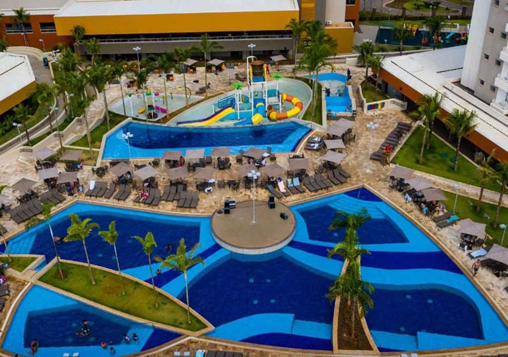 Área de piscinas do Enjoy Solar das Águas Park Resort, com parque aquático infantil e espreguiçadeiras