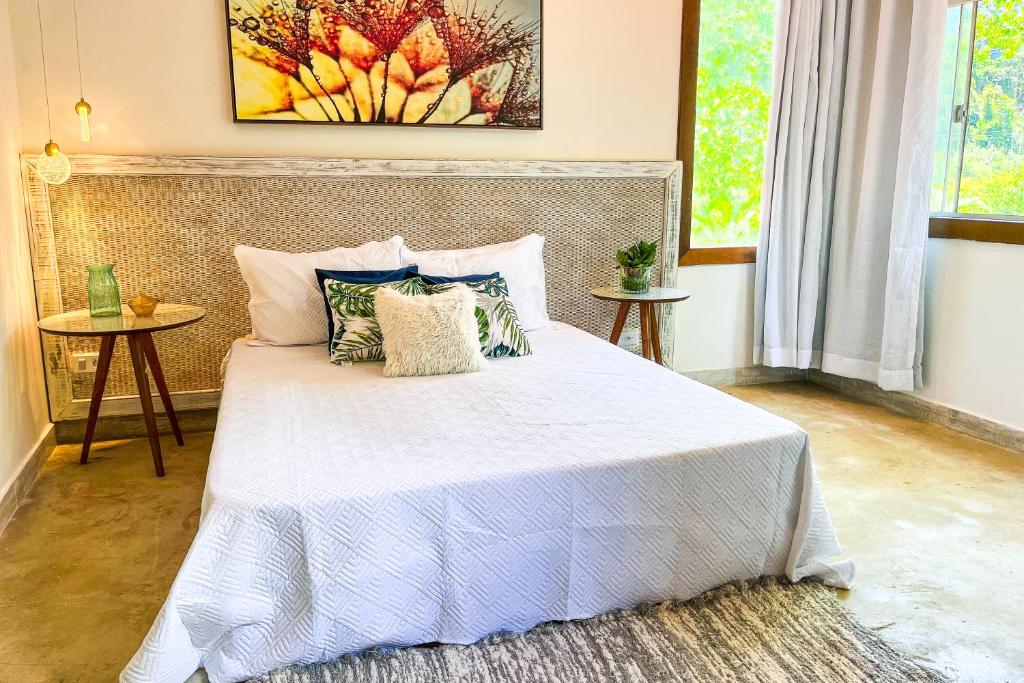 Quarto da Pousada Sonho Real, em Angra dos Reis, com decoração em tons claros.