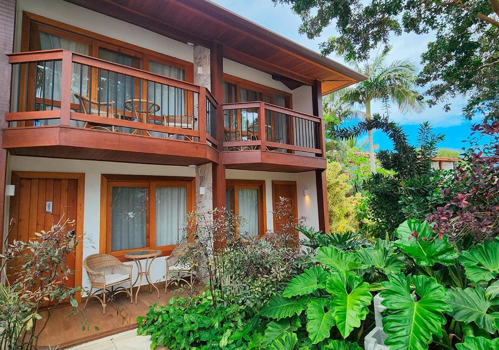 Fachada da Blu Smart Stay, em Búzios, entre jardins e varandas de madeira.