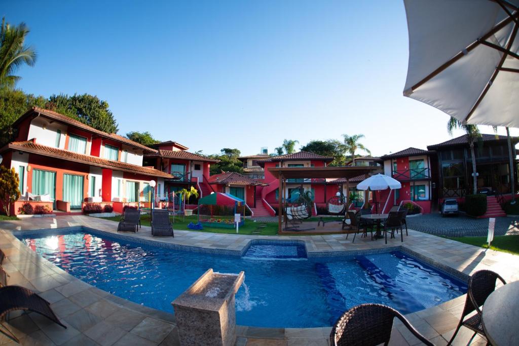 Piscina da Pousada dos Guardiões, em Búzios, diante de edifícios vermelhos.