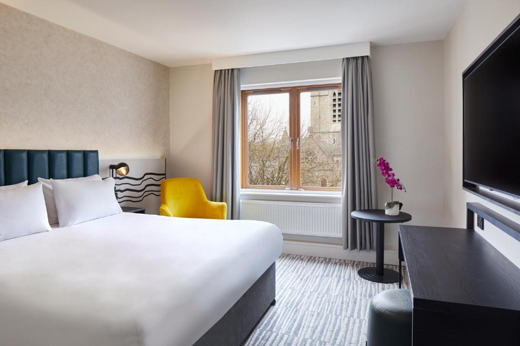 Quarto do Leonardo Hotel Dublin Christchurch, em Dublin, com poltrona amarela.