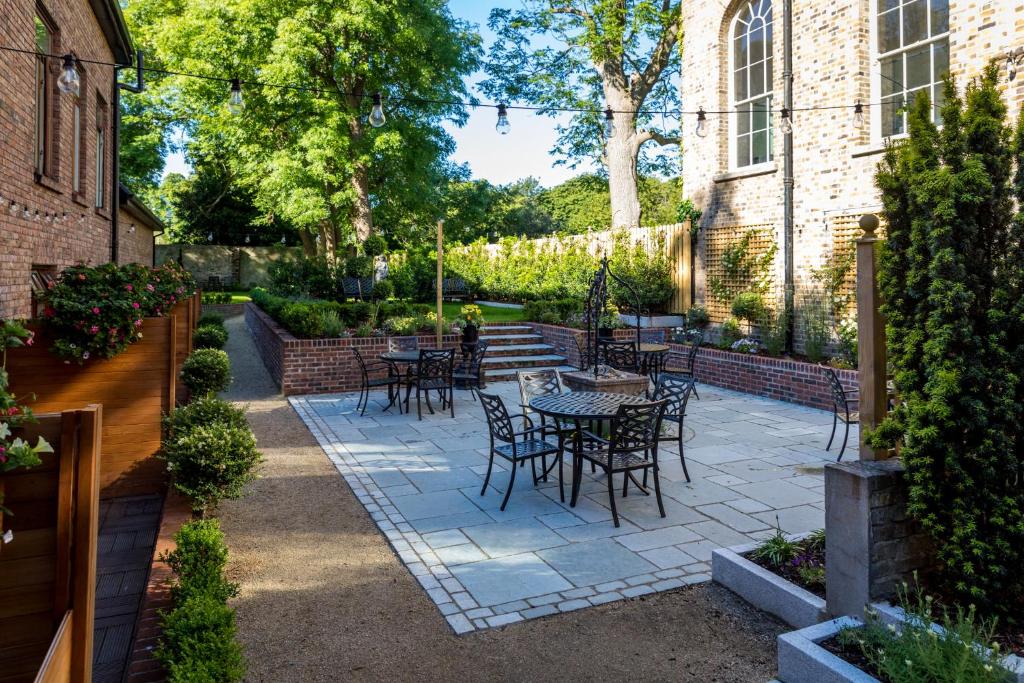 Jardim do Stautons on the Green Hotel, em Dublin, com mesas ao ar livre.