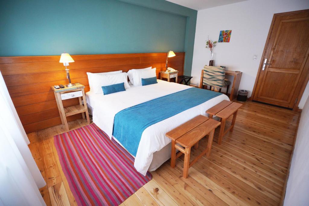 Quarto do Destino Sur Hotel & Spa de Montaña, em El Chaltén, com cama ampla e detalhes azuis.