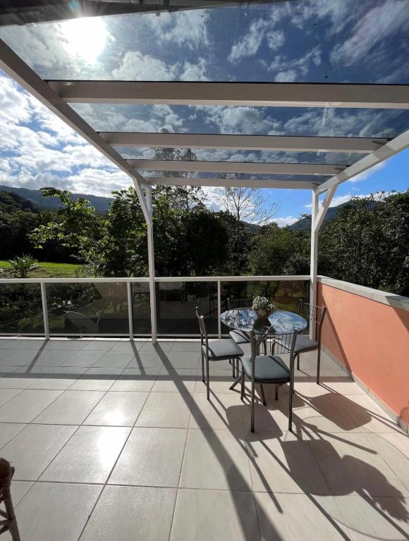 Varanda do Loft com Linda Vista na Rota do Enxaimel, em Pomerode, com mesa e vista para a mata.