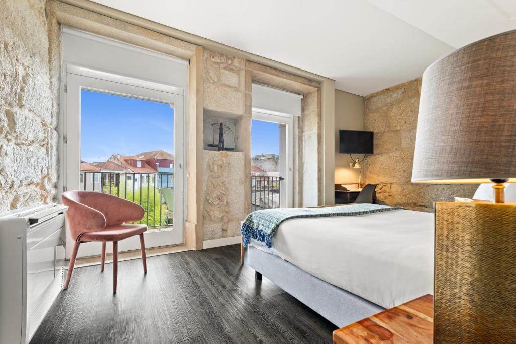 Quarto do Jardim da Batalha Boutique Hotel by Shiadu, no Porto, com paredes de pedra e janela para a cidade