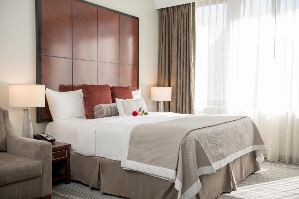 Quarto do Club Donatello, em San Francisco, com cama de casal e janela ampla.