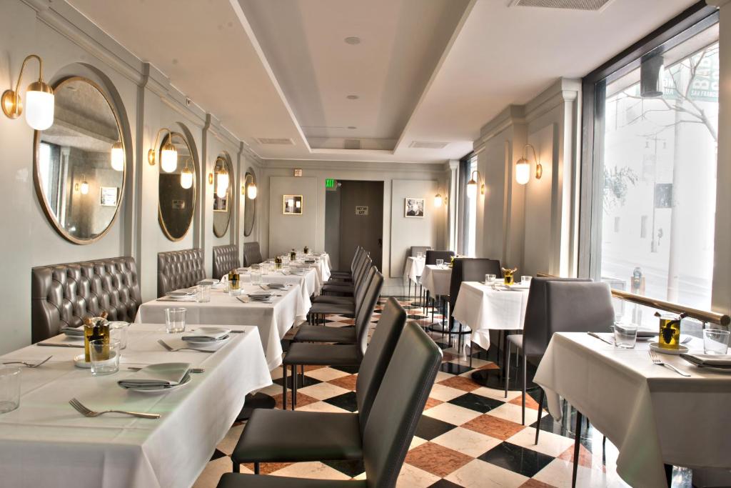 Restaurante do Club Donatello, em San Francisco, com mesas preparadas para refeições.