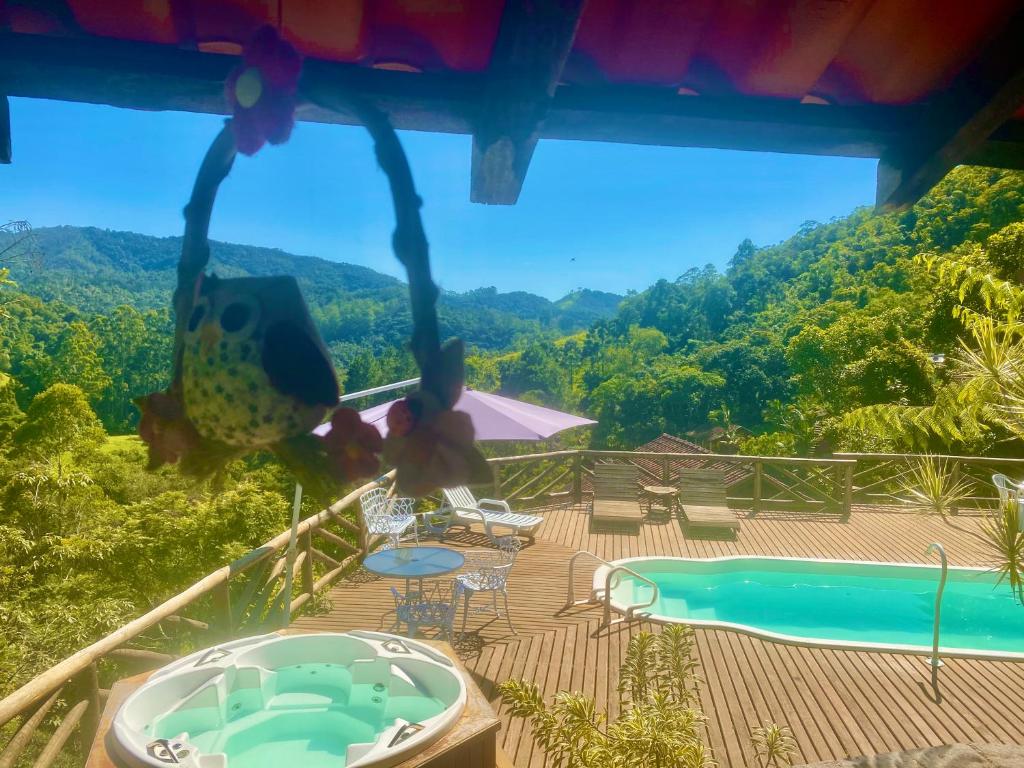 Área externa da Pousada Magia da Montanha, em Visconde de Mauá, com piscina, hidromassagem e vista para montanhas