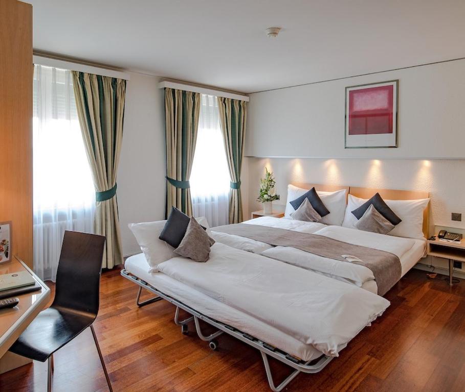 Quarto do Hotel Krone Unterstrass, em Zurique, com cama de casal e sofá-cama.