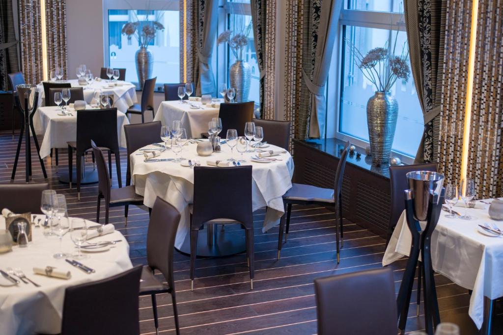Restaurante do Hotel Krone Unterstrass, em Zurique, com mesas elegantes.