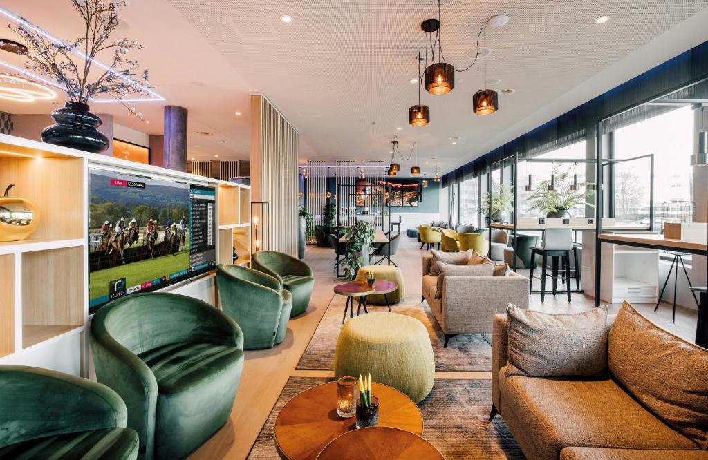 Lounge do Leonardo Hotel Zurich Airport, em Zurique, com sofás e área de convivência.