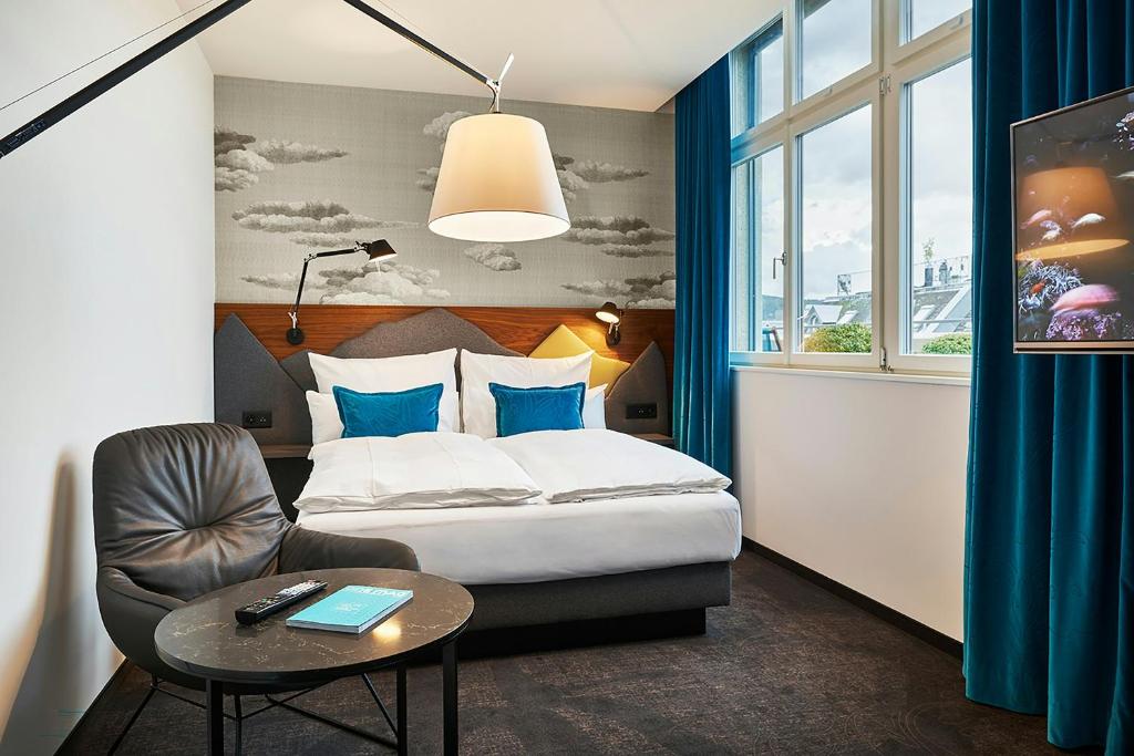 Quarto do Motel One Zürich, em Zurique, com detalhes em azul.
