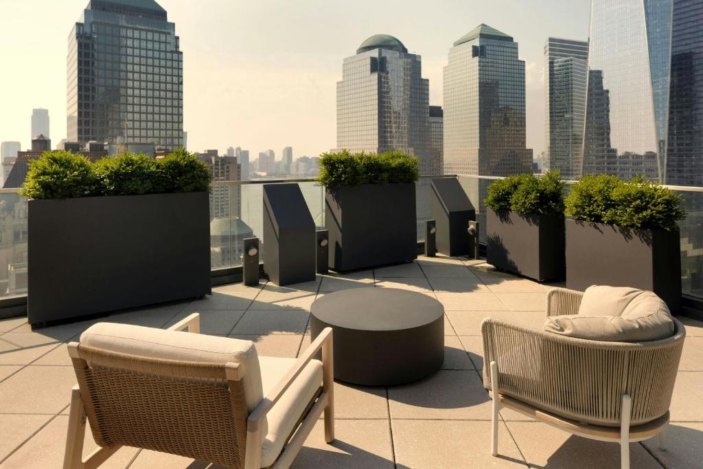 Terraço do The Cloud One New York Downtown by the Motel One, em Nova York, com poltronas e vista para os arranha-céus.